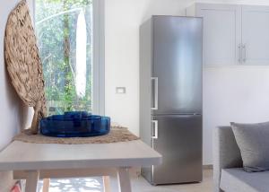 uma cozinha com uma mesa e um frigorífico de aço inoxidável em Maria grazia em Casale Alxi