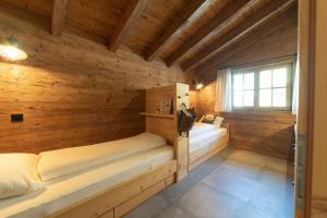 um quarto com 2 camas num chalé de madeira em Chalet Schibenstoll em Wildhaus