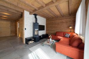 a living room with a red couch and a fireplace at Chalet Schibenstoll in Wildhaus