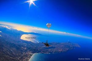 a person riding a hot air balloon in the sky at apartment over the sea Private place to swim in Ravdhoúkha