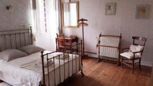 1 dormitorio con 1 cama, mesa y sillas en La Cure du Maine Charles en Birac