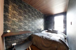 東京的住宿－s-rea TOKYO 201，一间卧室配有一张床、一把椅子和一面墙