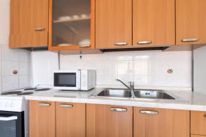 una cucina con lavello e microonde di Apartment Valkovic a Baška Altre 5 foto