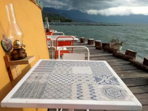 a table sitting on a dock next to the water at Hotel Maninjau Indah - The Lakeside Resort in Maninjau