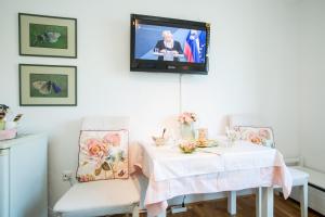 a room with a table and two chairs with a tv on the wall at B&B Pletna a Double Lake-View Room in Bled