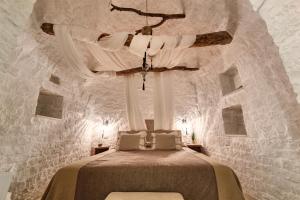 a bedroom with a bed in a stone wall at Leonardo Trulli Resort in Locorotondo