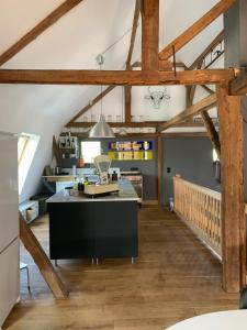 a kitchen with a black island in a room with wooden beams at Design Appartment with big Terrace in Halsenbach