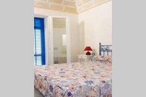 ein Schlafzimmer mit einem Bett mit einer farbenfrohen Tagesdecke in der Unterkunft Il Ritrovo di Archimede in Favignana
