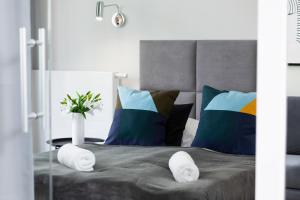 um quarto com uma cama com almofadas e um vaso em Apartments Browary Warszawskie by Renters em Varsóvia