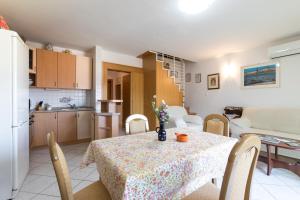 kuchnia i jadalnia ze stołem i krzesłami w obiekcie Glorija w Bašce