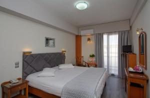 a bedroom with a large bed and a window at Hotel Nefeli in Volos