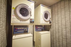 a laundry room with two washing machines and a washer at hotel MONday Asakusa in Tokyo +78 photos