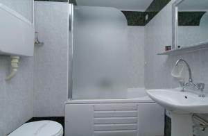 a white bathroom with a sink and a toilet at Hotel Nefeli in Volos
