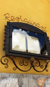 a clock on the side of a yellow wall at Hotel De La Poste in Cortina dʼAmpezzo