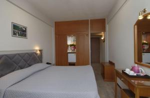 a bedroom with a bed and a table and a drawer at Hotel Nefeli in Volos