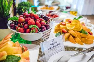 a table topped with bowls of fruit and snacks at Zhemchuzhina Grand Hotel in Sochi
