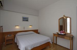 a bedroom with a bed and a mirror at Hotel Nefeli in Volos