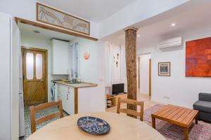 a kitchen and a living room with a table and chairs at Charming La Latina Royal Palace Apartment in Madrid