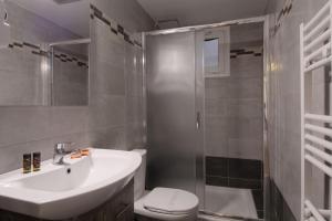a bathroom with a sink and a toilet and a shower at Hotel Nefeli in Volos