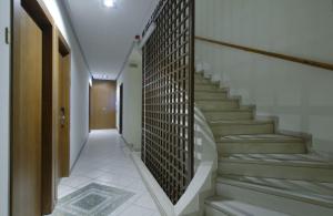 a hallway with stairs and a wall with a tile floor at Hotel Nefeli in Volos