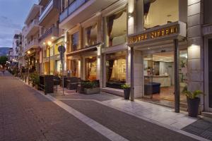 una strada con un mucchio di negozi di Hotel Nefeli a Volos