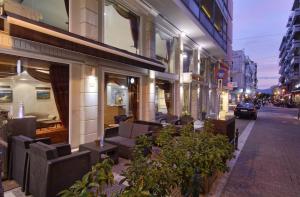 a building with chairs and tables on a city street at Hotel Nefeli in Volos