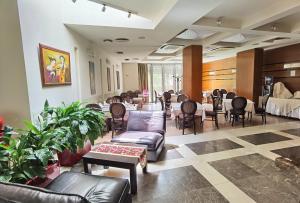 a waiting room with couches and tables and chairs at Aqua Viva Spa Hotel in Velingrad