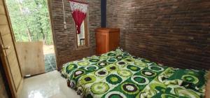 a bedroom with a bed in a brick wall at Homestay Kurnia in Bantul