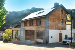 a wooden building with a car parked in front of it at JUULS - Natur Hotel Garni in Simmerath