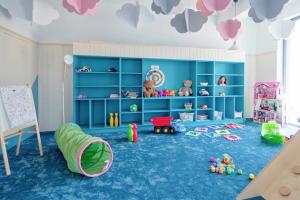 a childs play room with blue carpet and toys at Apartamenty Rodzinne Deluxe, Suite w budynku Baltin in Sarbinowo