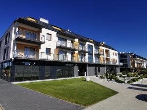 a large building with a lawn in front of it at Apartamenty Rodzinne Deluxe, Suite w budynku Baltin in Sarbinowo