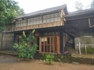 a wooden house with a door and a porch at Homestay Kurnia in Bantul