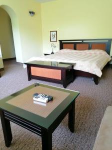 サラタ・モンテオルにあるHotel Monteoruのベッド1台、テーブル、ベッドサイドシックスが備わる客室です。