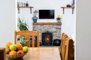 a table with a bowl of fruit and a fireplace at The Arch An Capall Dubh Dingle in Dingle