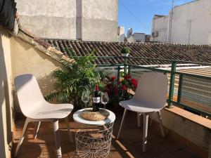2 sillas blancas y una botella de vino en el balcón en ISA Granada, en Granada