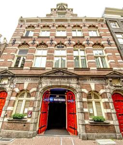 ein großes Backsteingebäude mit roten Türen und Fenstern in der Unterkunft Best Western Dam Square Inn in Amsterdam