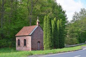 uma pequena capela de tijolos ao lado de uma estrada em Ferienwohnung auf dem Dorf, Külsheim em Külsheim