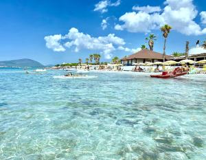 a beach with a group of boats in the water at Lido di Alghero Beach Resort - La Villetta in Alghero