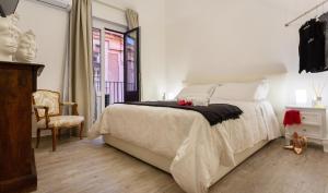 a bedroom with a bed and a chair and a window at Duomo Luxury Suite Catania in Catania