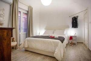 a white bedroom with a large bed and a window at Duomo Luxury Suite Catania in Catania