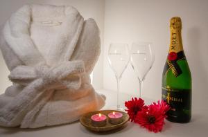 a bottle of champagne next to two glasses and a statue at Duomo Luxury Suite Catania in Catania