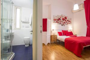 a bedroom with a red bed and a bathroom at Smart Lodgings Plus in Rome