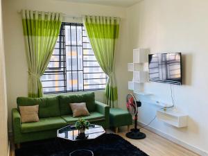 a living room with a green couch and a window at LY'S Căn hộ Homestay Phan Rang-2pn in Phan Rang–Tháp Chàm