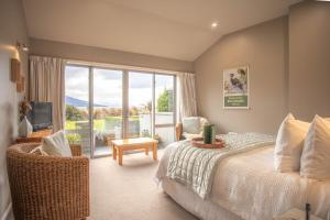 a bedroom with a bed and a large window at Dunluce Boutique B&B in Te Anau