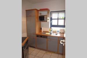 una pequeña cocina con fregadero y microondas en Ferienwohnung Zoll, en Unterkirnach