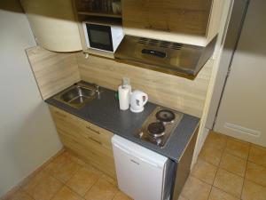 uma pequena cozinha com um lavatório e um fogão em Condo Gardens Leuven - Large One Bedroom em Lovaina