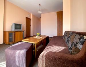 ein Zimmer mit einem Sofa, einem Tisch und einem Fernseher in der Unterkunft Vanessa Family Hotel in Rawda