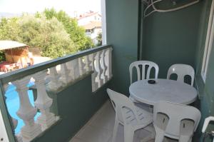 a balcony with a table and white chairs on a balcony at Club Sunset Apartments in Marmaris