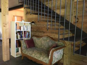 sala de estar con silla y escalera en A Côté en Oron-la-ville