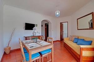 ein Wohnzimmer mit einem Tisch und einem Sofa in der Unterkunft Albufeira Beach by Homing in Albufeira